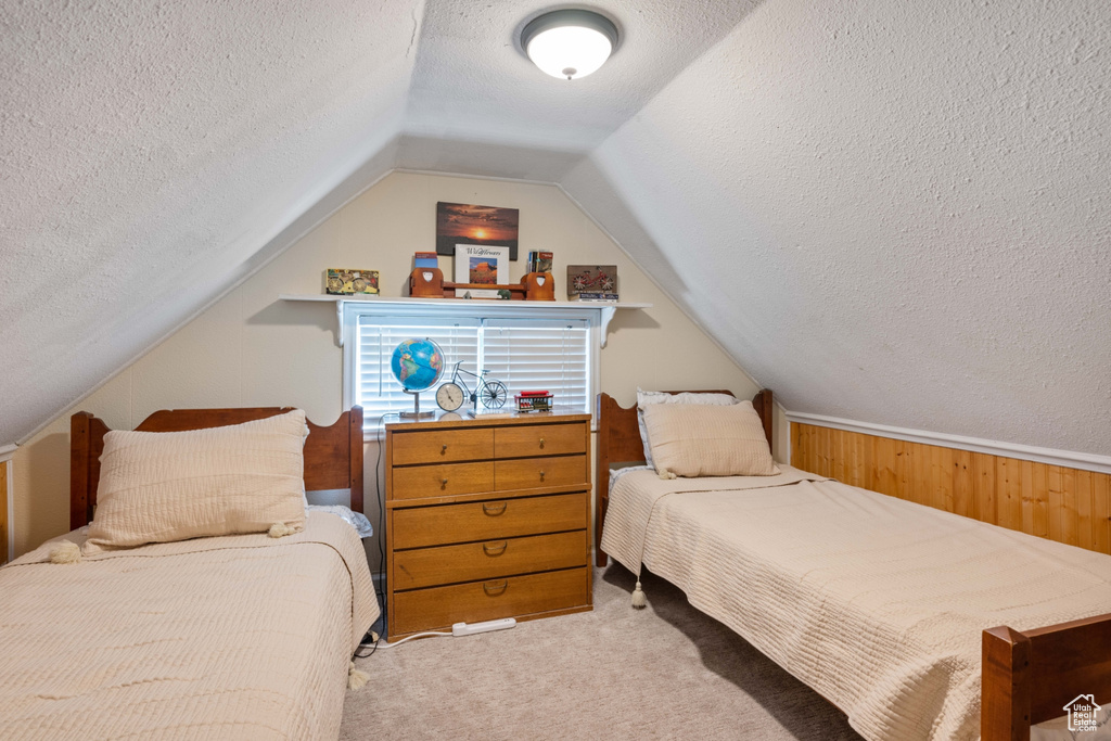 Bedroom featuring carpet floors, a textured ceiling, and vaulted ceiling