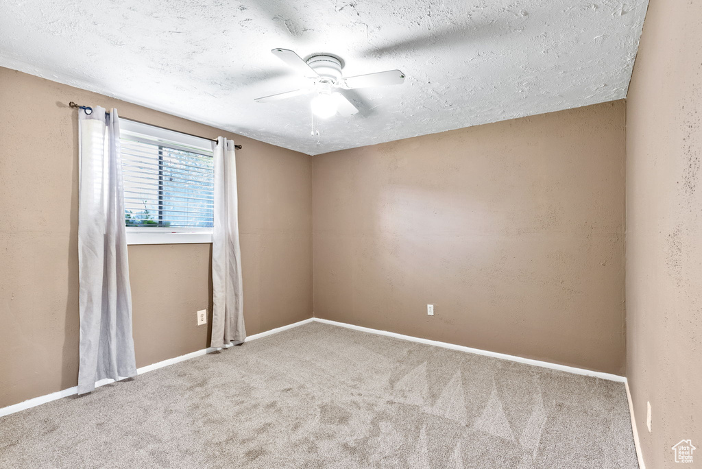 Spare room with carpet flooring, a textured ceiling, and ceiling fan