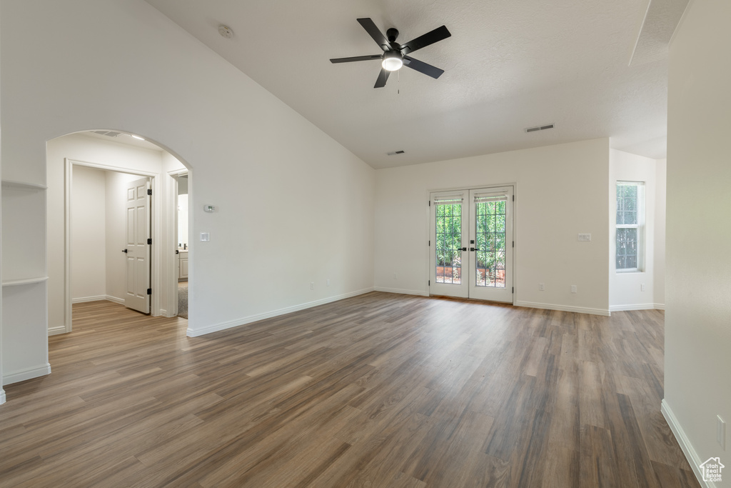 Spare room with high vaulted ceiling, hardwood / wood-style flooring, french doors, and ceiling fan