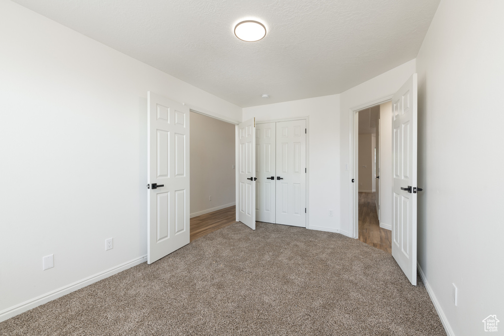 Unfurnished bedroom featuring a closet and carpet floors