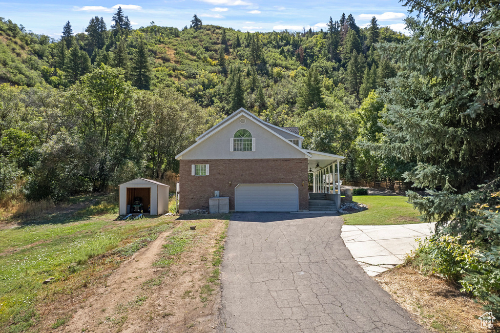 View of front facade featuring an outbuilding, a garage, and a front yard