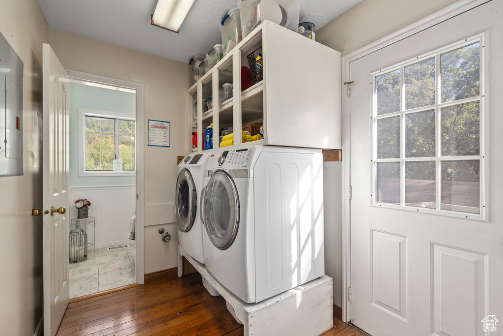 Washroom featuring washing machine and dryer and hardwood / wood-style floors