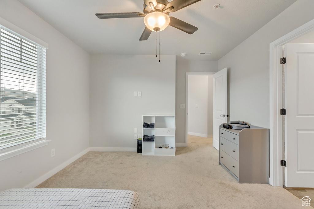 Unfurnished bedroom featuring light colored carpet and ceiling fan