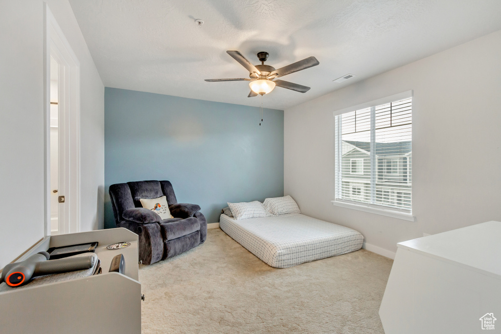 Carpeted bedroom featuring ceiling fan