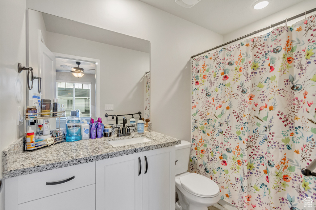 Bathroom featuring vanity, ceiling fan, and toilet