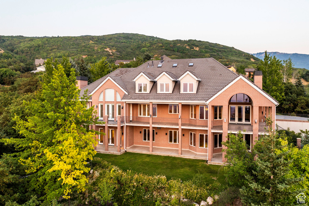 Back of house featuring a lawn and a mountain view