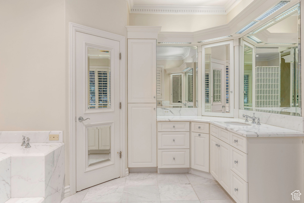 Bathroom with a tub, tile patterned floors, crown molding, and vanity