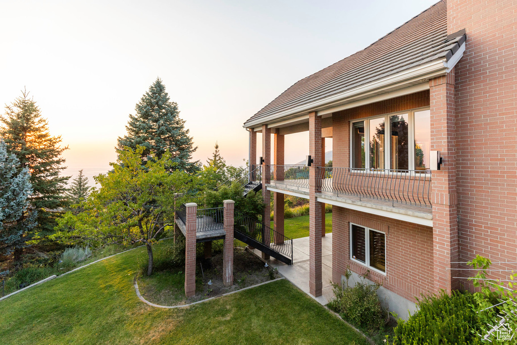 Yard at dusk featuring a balcony