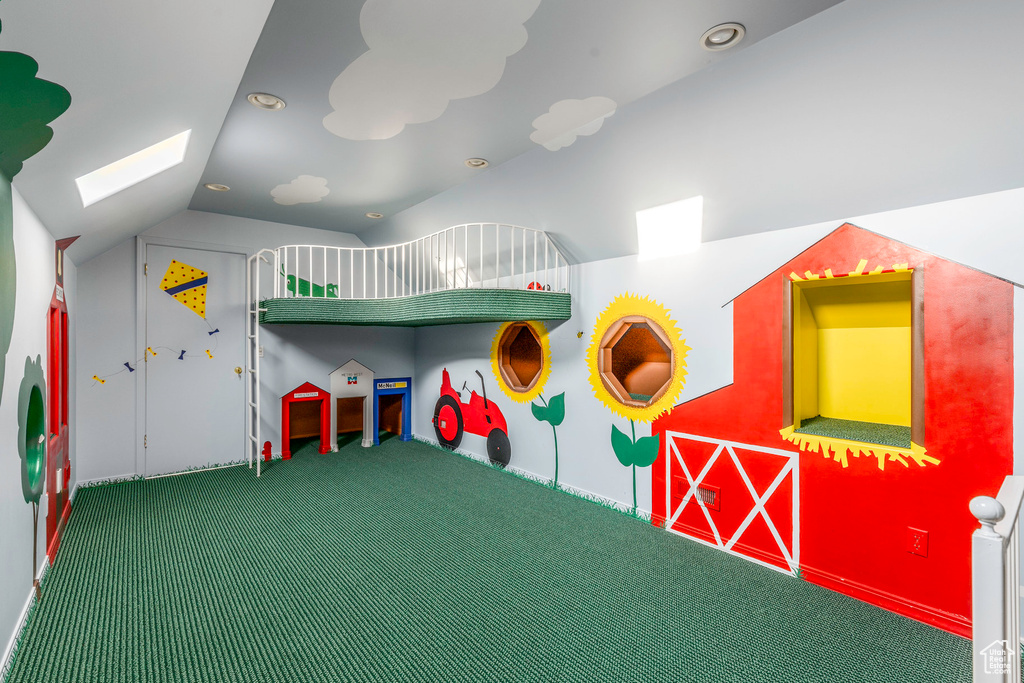 Rec room featuring carpet flooring and vaulted ceiling with skylight