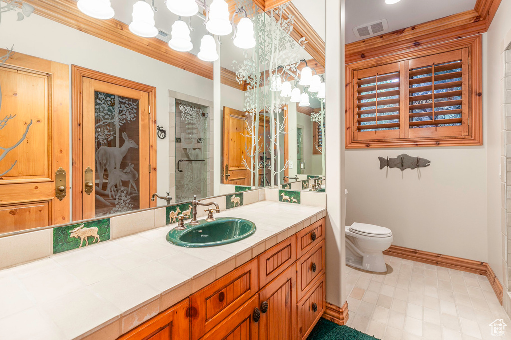 Bathroom with vanity, a shower with shower door, a notable chandelier, tile patterned flooring, and toilet