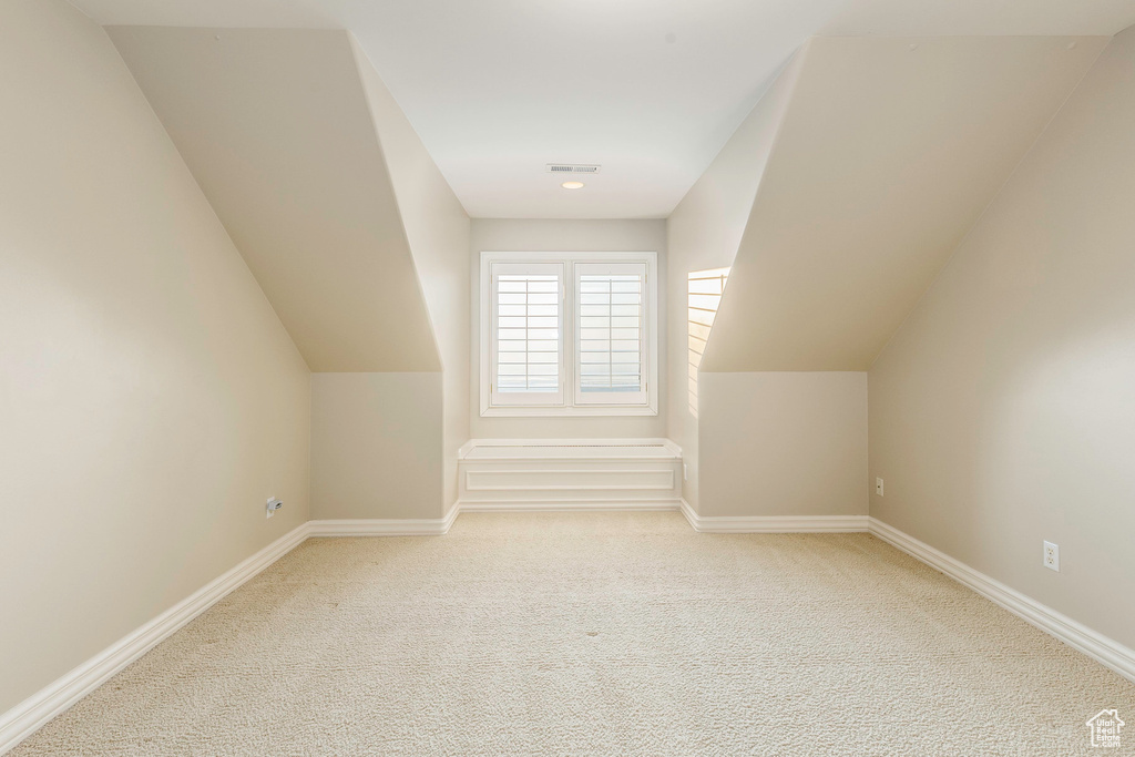 Bonus room featuring light colored carpet