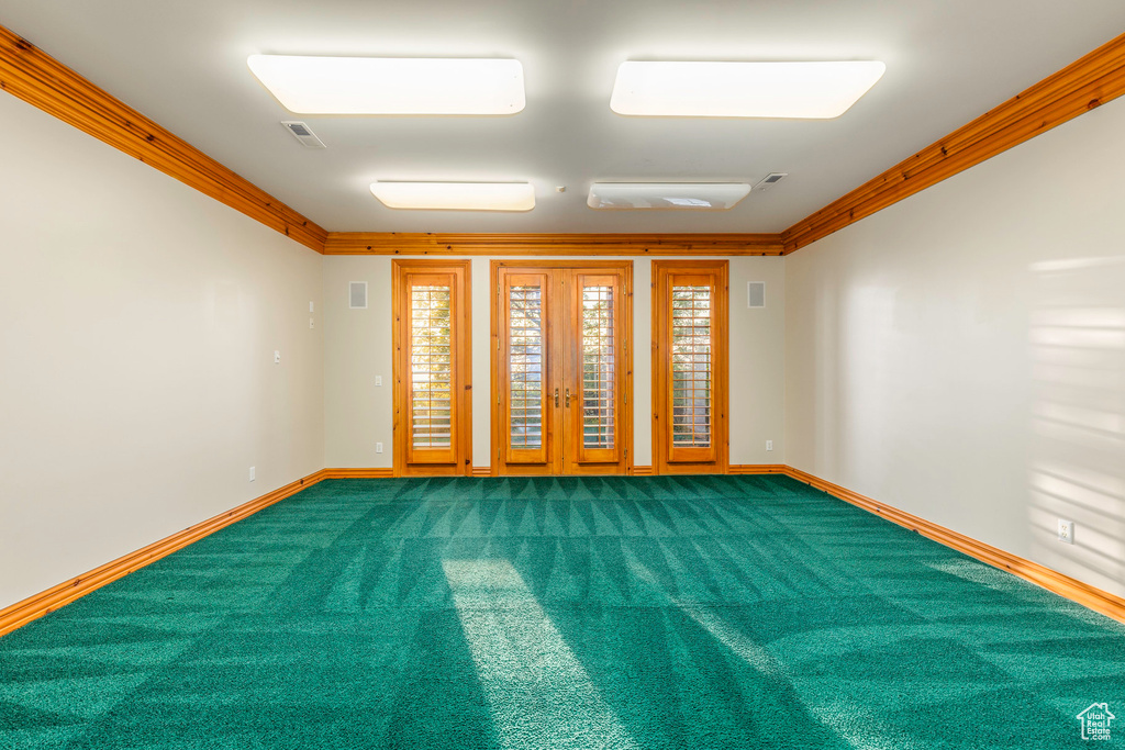 Carpeted empty room featuring ornamental molding