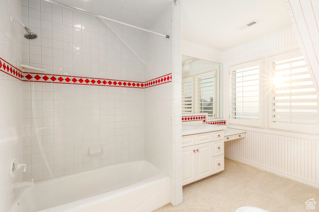 Bathroom with tiled shower / bath combo and vanity