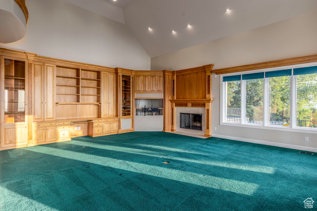 Unfurnished living room with a fireplace, built in features, high vaulted ceiling, and carpet floors