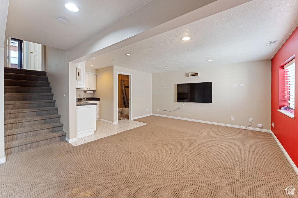 Unfurnished living room featuring light carpet