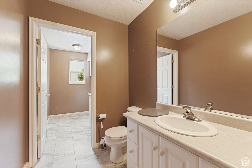 Bathroom featuring tile patterned floors, toilet, and vanity