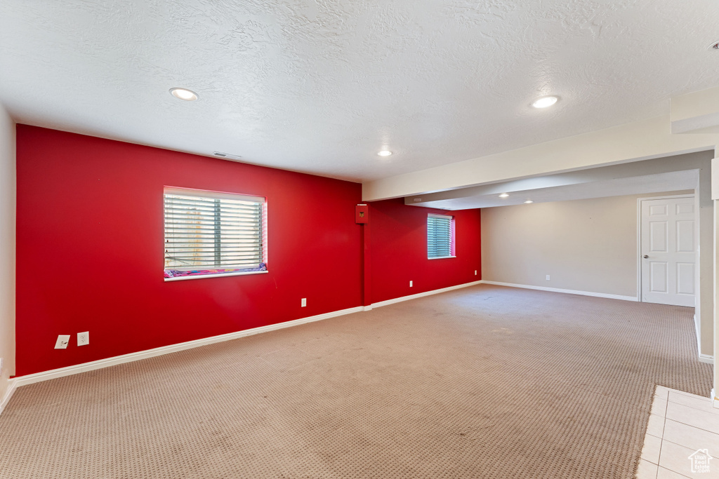 Empty room featuring carpet flooring and a textured ceiling