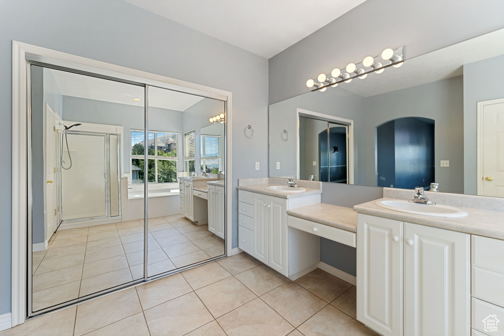 Bathroom with tile patterned flooring, dual vanity, and a shower with shower door