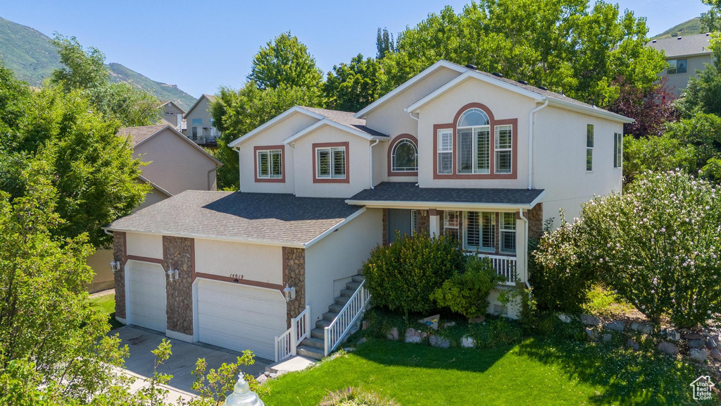 View of property featuring a mountain view and a front lawn