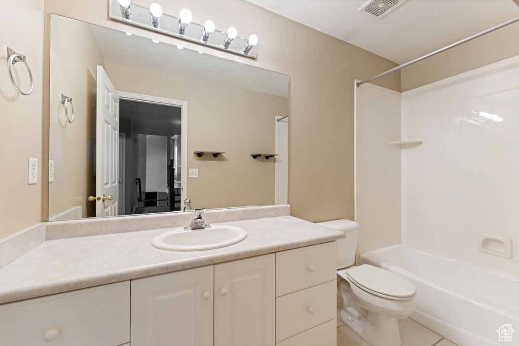 Full bathroom featuring vanity, shower / bath combination, tile patterned flooring, and toilet