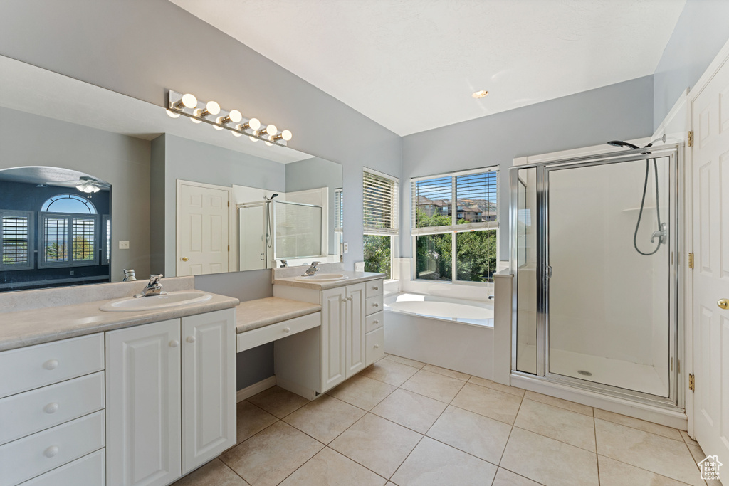 Bathroom featuring tile patterned flooring, separate shower and tub, and double vanity