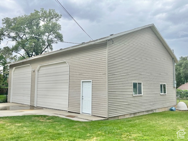 View of property exterior featuring a yard and a garage