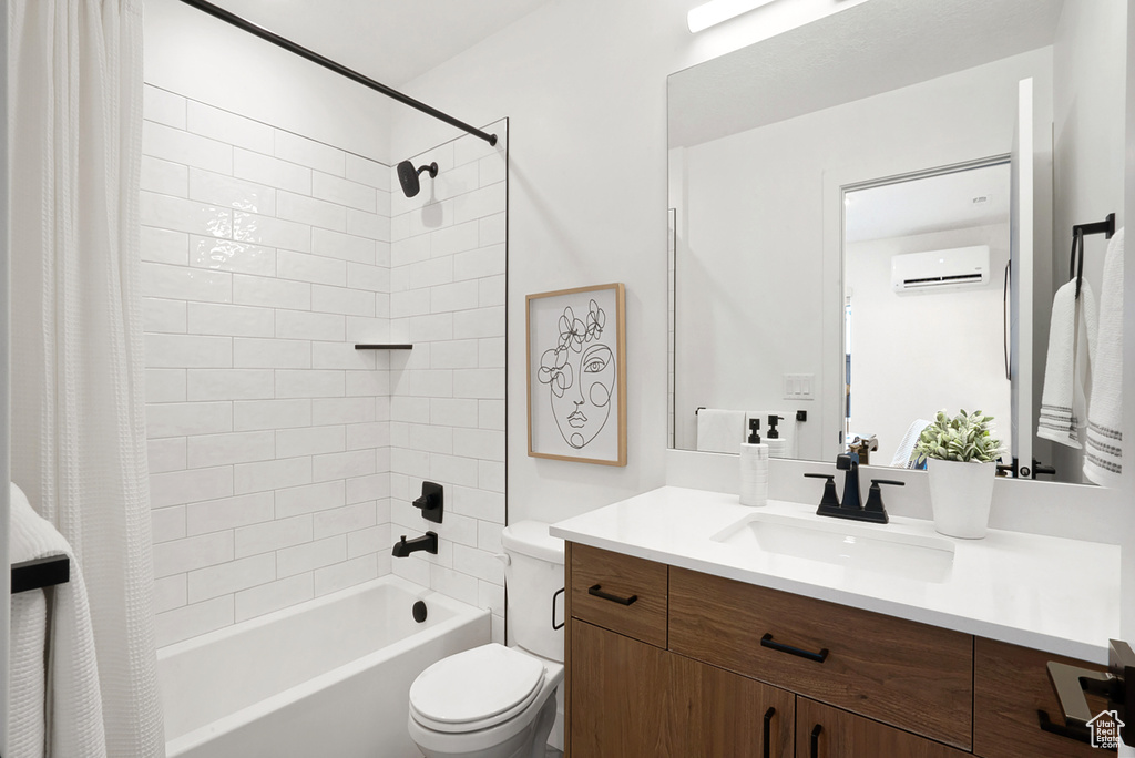 Full bathroom with vanity, a wall mounted AC, toilet, and shower / bath combination with curtain