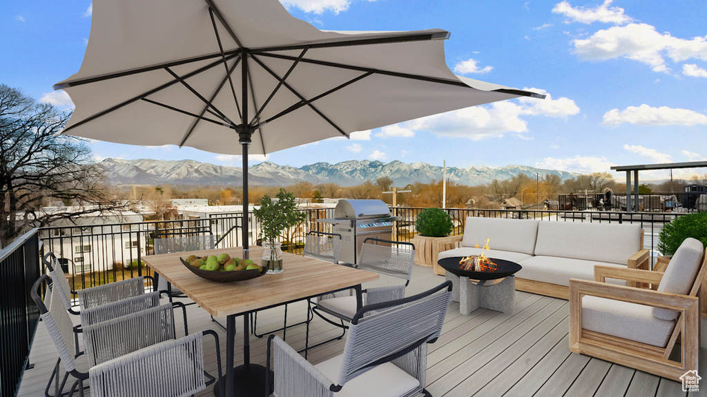 Wooden deck with grilling area, an outdoor living space with a fire pit, an outdoor kitchen, and a mountain view