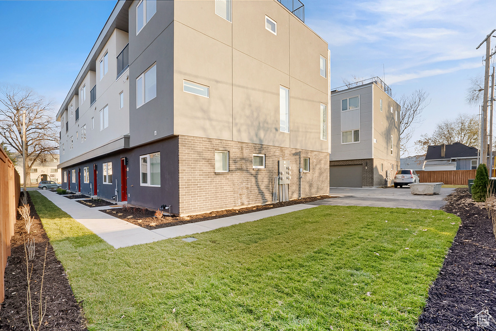 Exterior space with a garage and a lawn