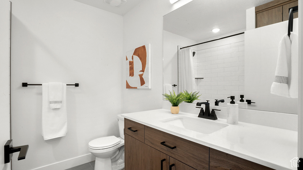 Bathroom featuring vanity, tile patterned flooring, and toilet