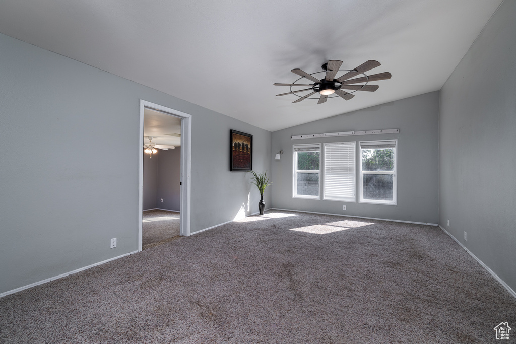 Unfurnished room with ceiling fan, carpet floors, and vaulted ceiling