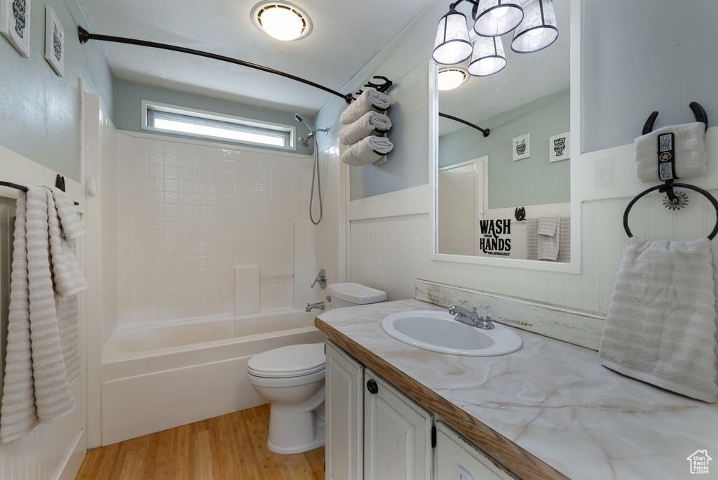 Full bathroom with vanity, toilet, hardwood / wood-style flooring, and shower / bathing tub combination