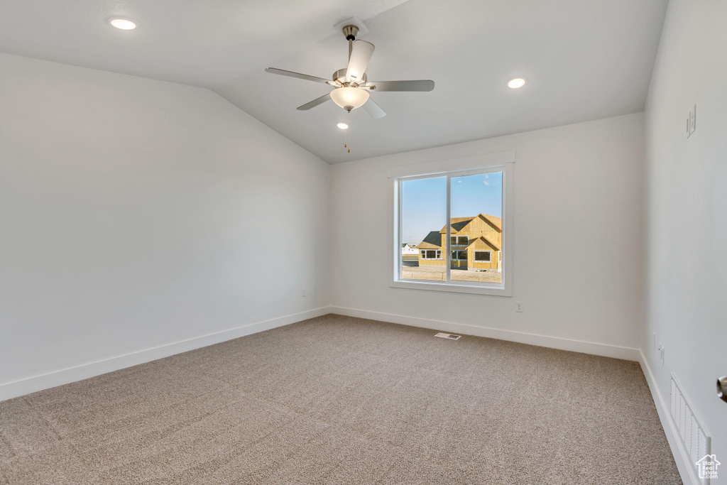 Carpeted spare room with lofted ceiling and ceiling fan