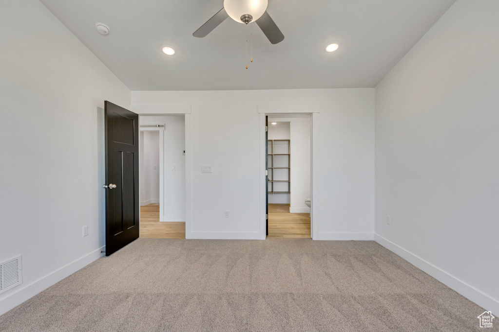 Unfurnished bedroom featuring light carpet and ceiling fan