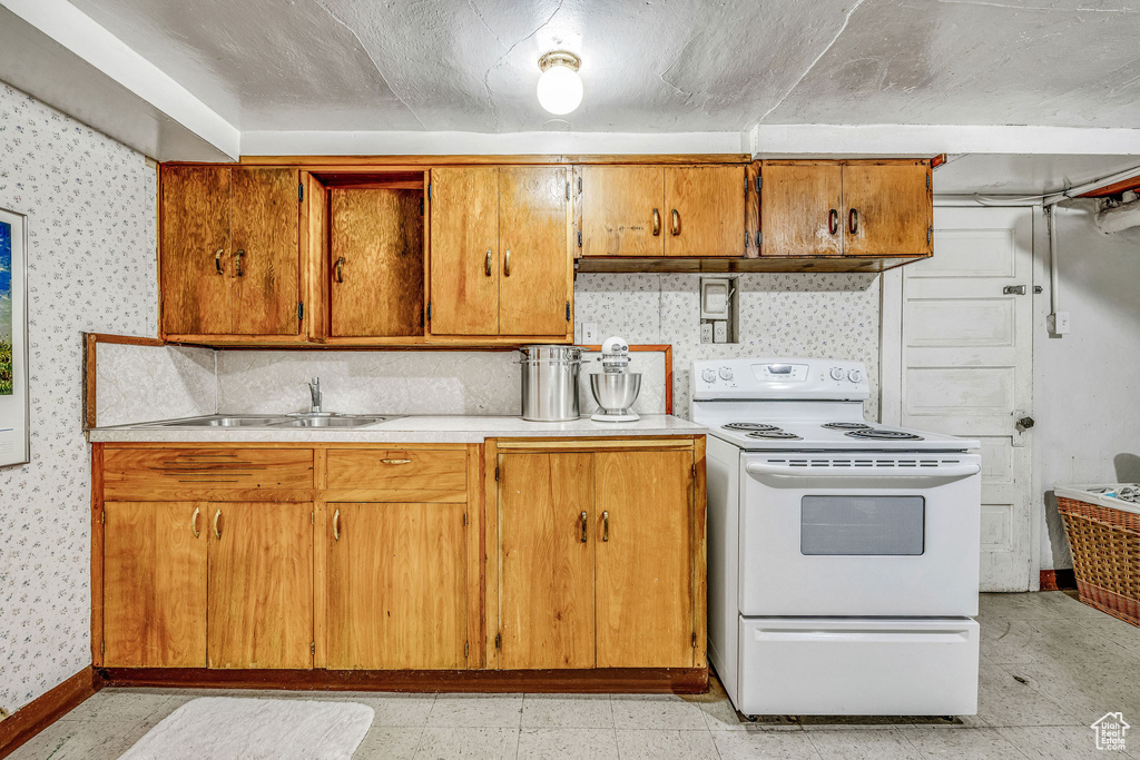 Kitchen with sink, white electric range, decorative backsplash, and light tile patterned floors
