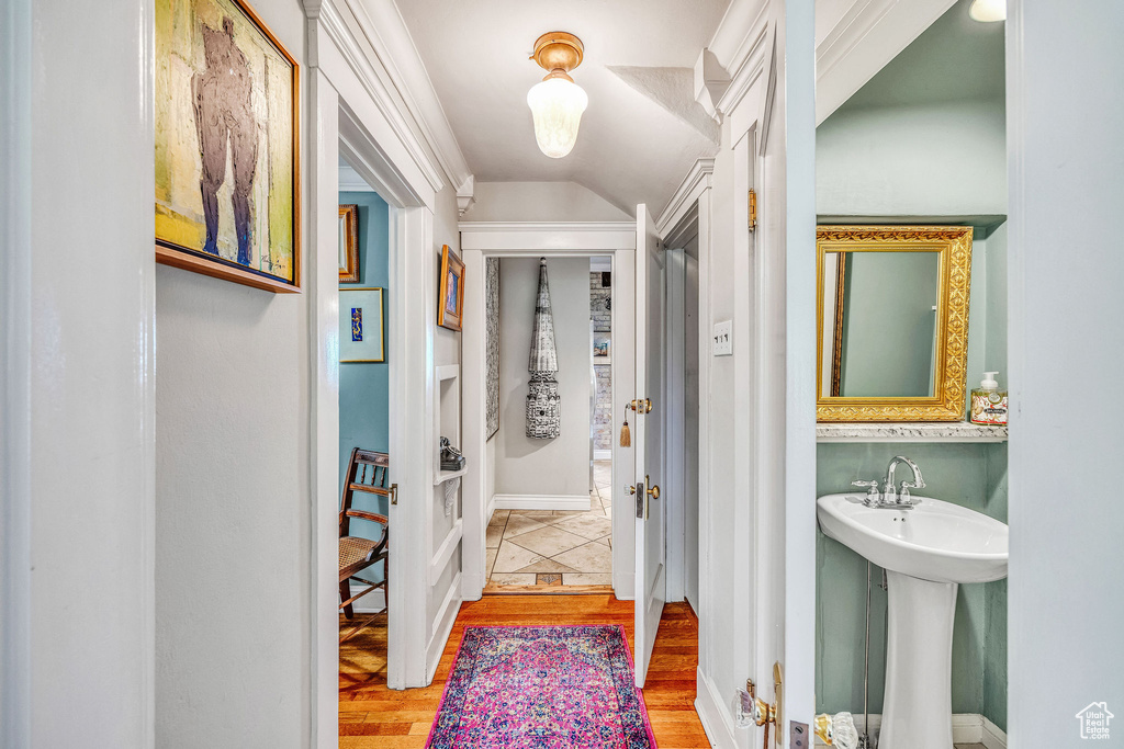 Hall with light hardwood / wood-style floors and vaulted ceiling