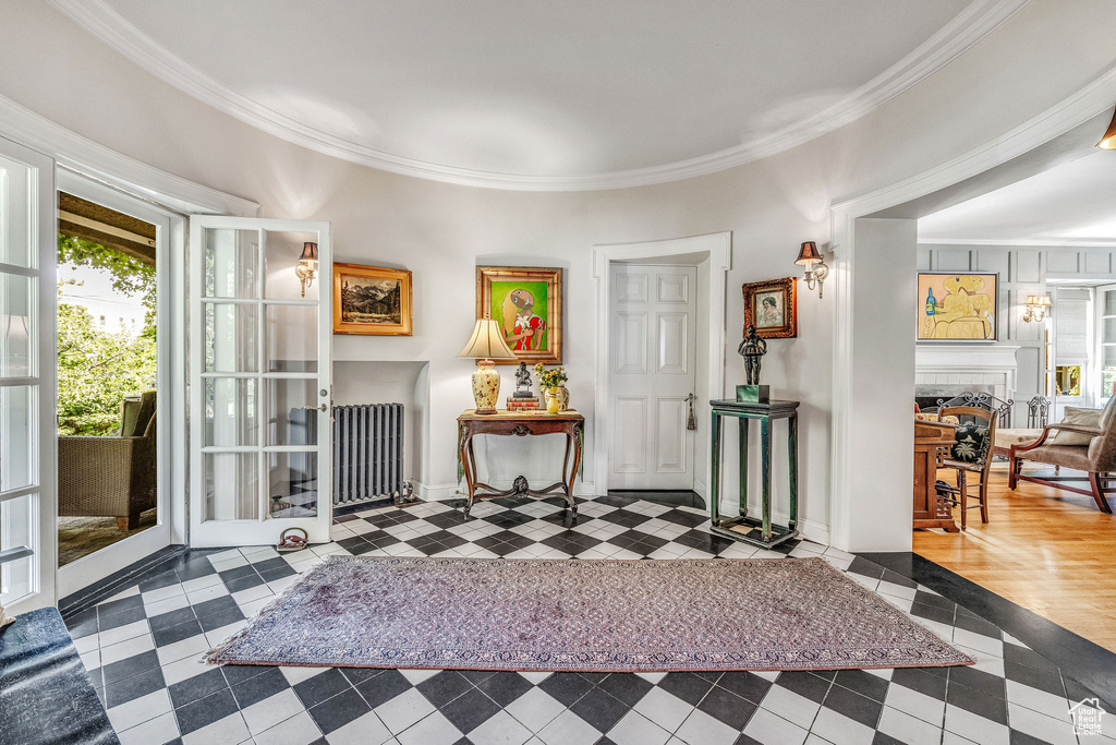 Sitting room featuring ornamental molding, radiator, a fireplace, and hardwood / wood-style flooring