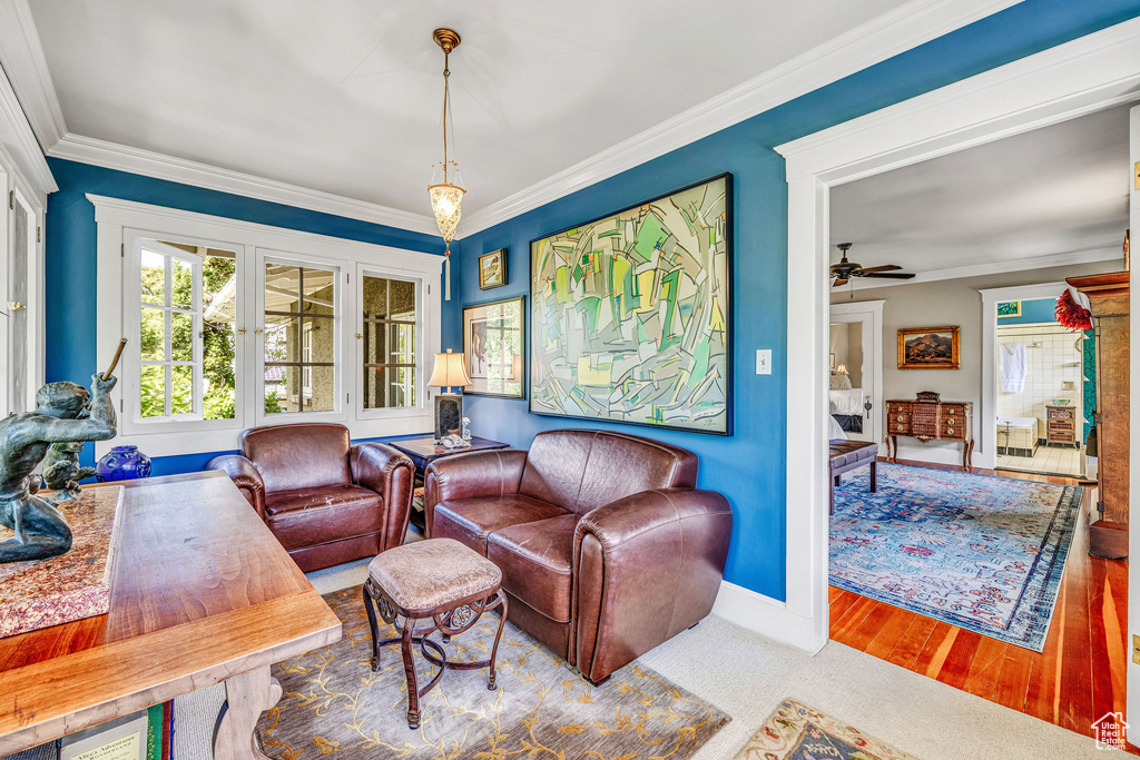 Living room with ornamental molding, hardwood / wood-style floors, and ceiling fan