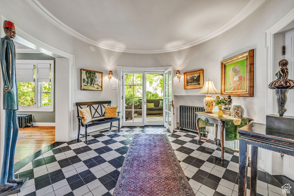 Living room featuring wood-type flooring, radiator, and ornamental molding