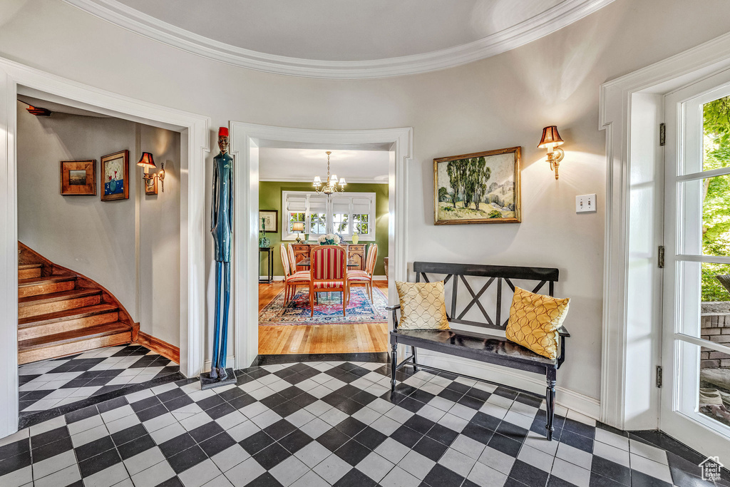 Corridor with ornamental molding, dark tile patterned floors, and plenty of natural light