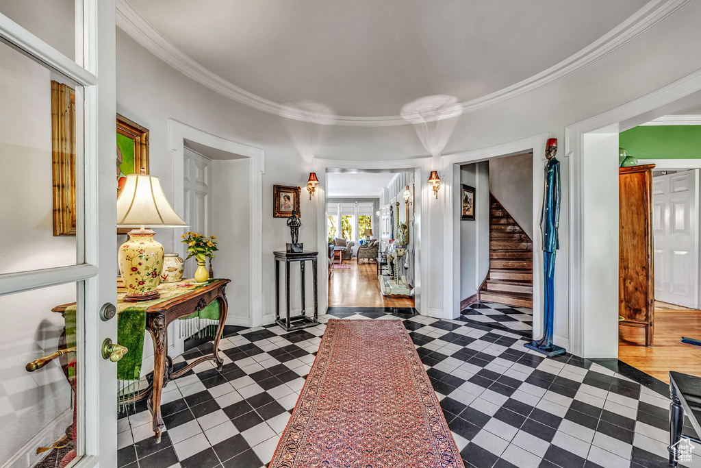 Foyer entrance with crown molding and hardwood / wood-style floors