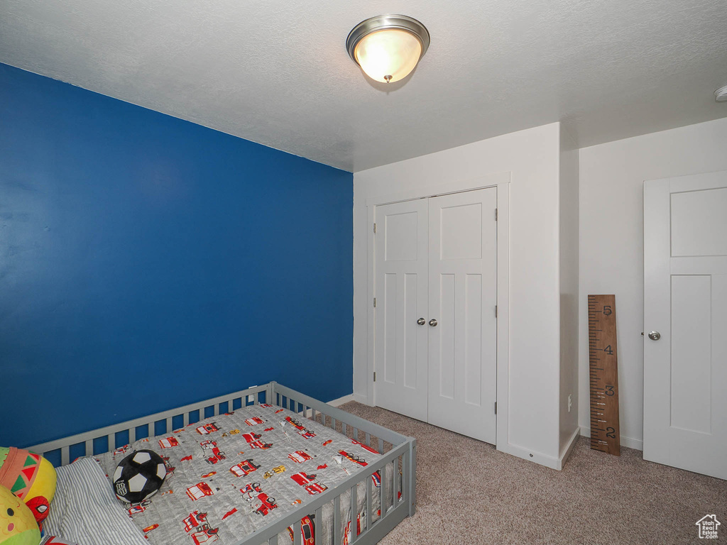 Unfurnished bedroom featuring a closet and light colored carpet