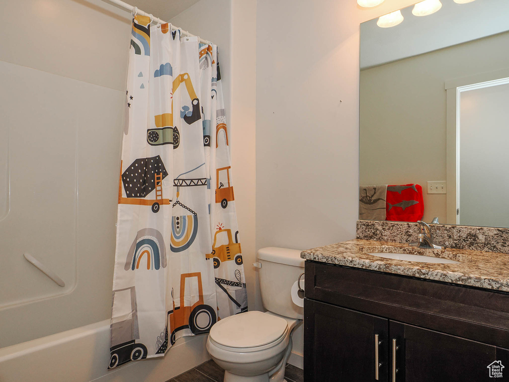 Full bathroom featuring vanity, toilet, and shower / bath combination with curtain