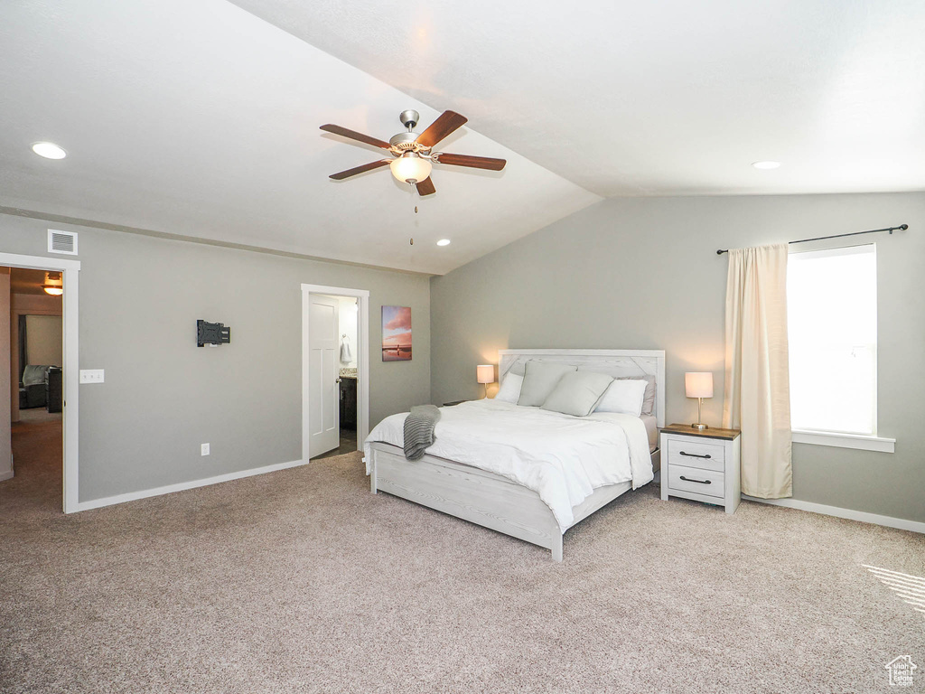 Carpeted bedroom with lofted ceiling and ceiling fan