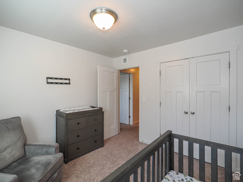 Carpeted bedroom with a closet