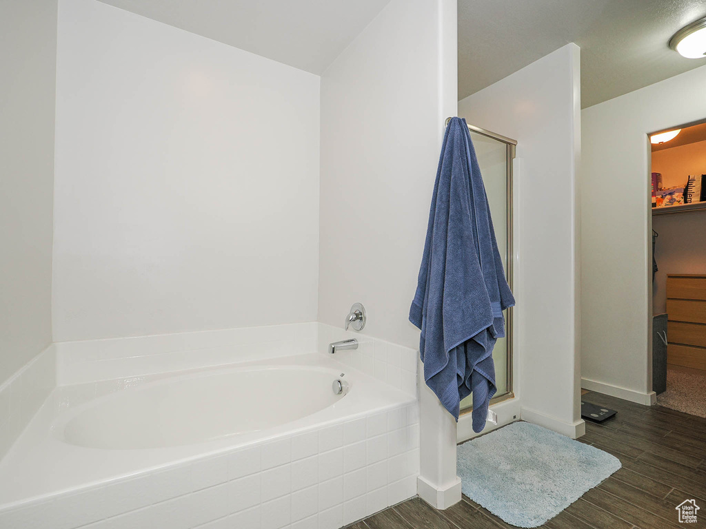 Bathroom with independent shower and bath and hardwood / wood-style flooring