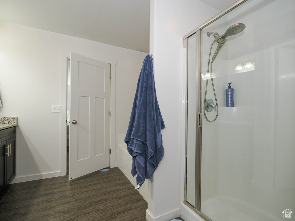 Bathroom with vanity, wood-type flooring, and an enclosed shower