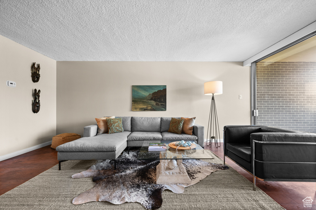 Living room featuring brick wall and a textured ceiling