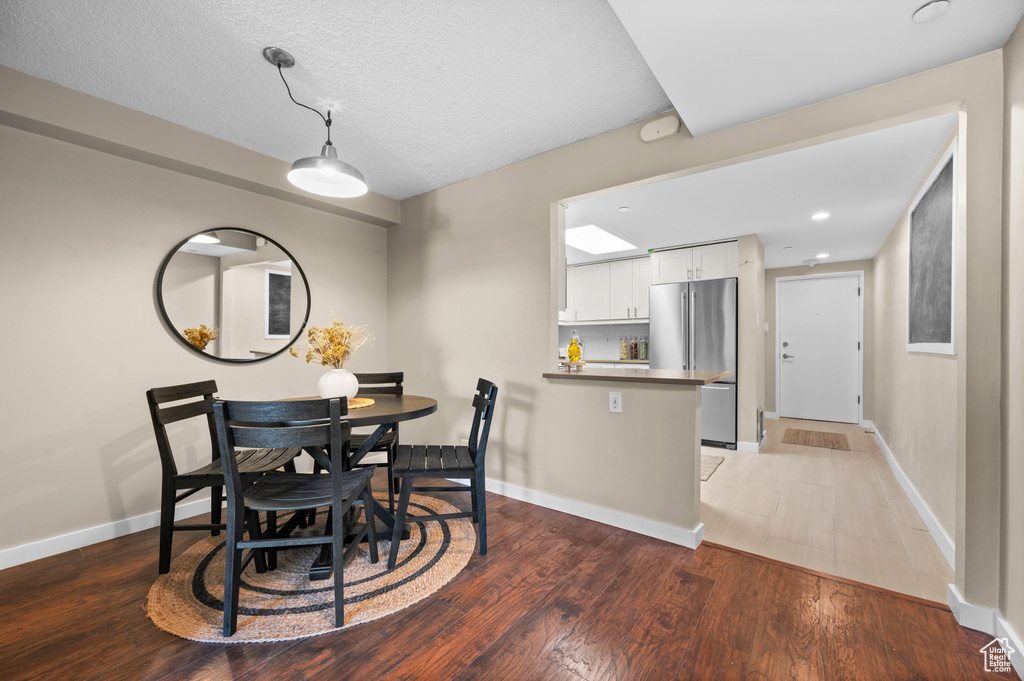 Dining room featuring a textured ceiling and hardwood / wood-style flooring