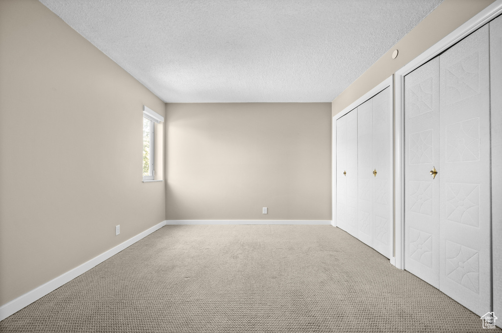 Unfurnished bedroom featuring carpet floors and a textured ceiling